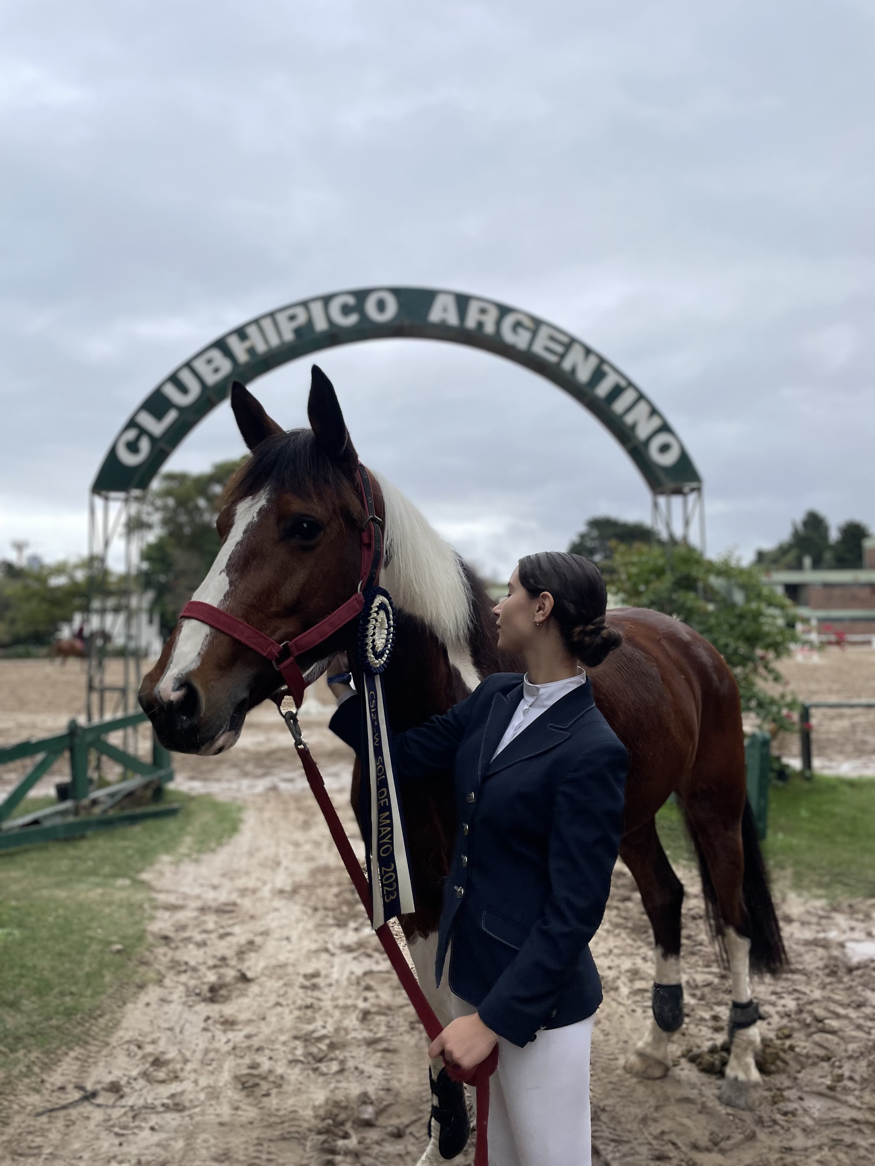 Lola y Comanche bajo el arco del Club Hípico Argentino
